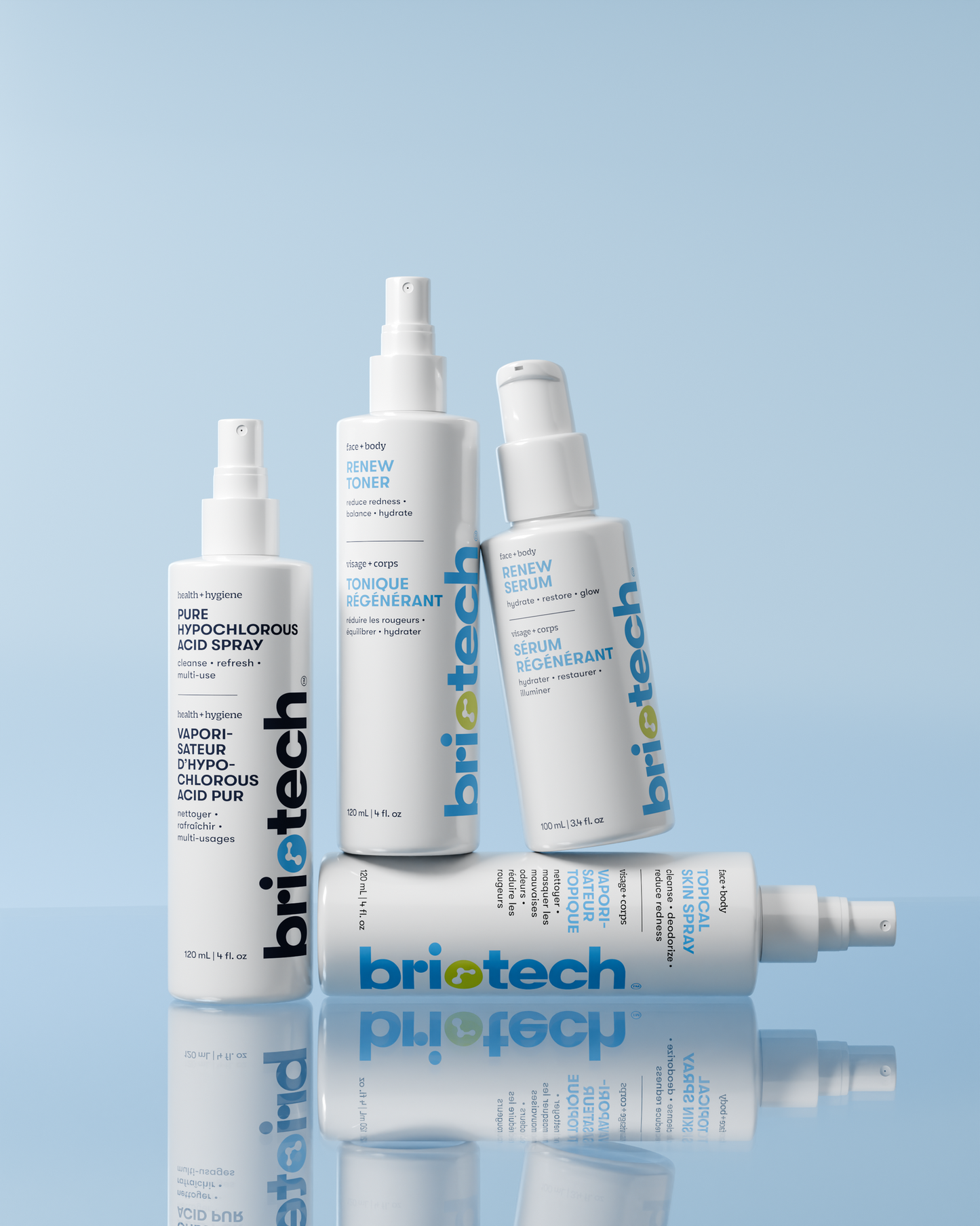 Four Briotech skincare products, including the Topical Skin Spray and serums, are arranged at various angles against a light blue background. The white bottles show blue and grey branding, formulated to calm irritation and reduce blemishes.